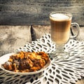 Tasty croissant with nuts and latte, croissant with coffee on white wooden table