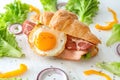 Tasty croissant sandwich with fried egg on white wooden table Royalty Free Stock Photo