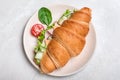 Tasty croissant sandwich with ham and cucumber on grey marble table, top view Royalty Free Stock Photo