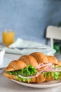 Tasty croissant sandwich with ham and cucumber on table Royalty Free Stock Photo