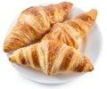 Tasty crusty croissants on the plate on white background. Top view. File contains clipping path