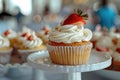 Tasty cupcake with creamy topping and slice of strawberry on the top, sweet buffet