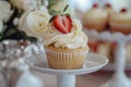 Tasty cupcake with creamy topping and slice of strawberry on the top, sweet buffet Royalty Free Stock Photo