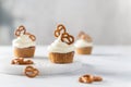 Tasty cupcakes with cream cheese decorated with brezel on white marble board on light background. Party, happy birthday, pastry, Royalty Free Stock Photo