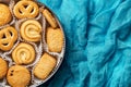 Tasty danish butter cookies in a tin over crumpled turquoise cloth. Open container with assorted shortbread biscuits. Baked pastry Royalty Free Stock Photo