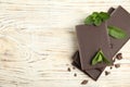 Tasty dark chocolate pieces with mint on white wooden table, flat lay. Space for text Royalty Free Stock Photo