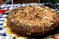 A tasty and delicious chocolate cake with colorful drops on top of it