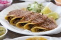 Tasty and delicious Mexican tacos garnished  with salsa and sliced lime Royalty Free Stock Photo