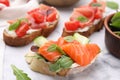 Tasty different bruschettas on white marble table, closeup