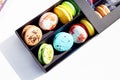 Tasty different colored macarons in black box on light background Royalty Free Stock Photo