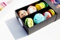 Tasty different colored macarons in black box on light background Royalty Free Stock Photo