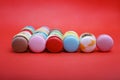 Tasty different colored macarons on red backgroundn Royalty Free Stock Photo