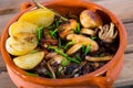 Tasty different mushrooms cooked at clay pot with potatoes at table