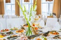 Tasty dishes at the wedding reception. White flowers on tables