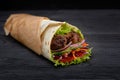 Tasty doner kebabs with fresh salad trimmings and shaved roasted meat served in tortilla wraps on brown paper as a