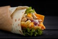 Tasty doner kebabs with fresh salad trimmings and shaved roasted meat served in tortilla wraps on brown paper as a