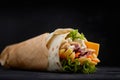 Tasty doner kebabs with fresh salad trimmings and shaved roasted meat served in tortilla wraps on brown paper as a