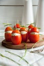 Stuffed tomato with chicken, garlic and cream cheese pasta lying on a brown wooden board