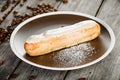 Tasty eclair with cream and coffe beans Royalty Free Stock Photo