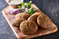 Tasty falafel pieces on wooden bread board