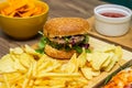 Tasty fast food on table. Pepperoni pizza and pizza Capricciosa , hamburger and potato chips Royalty Free Stock Photo