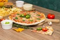 Tasty fast food on table. Pepperoni pizza and pizza Capricciosa , hamburger and potato chips Royalty Free Stock Photo