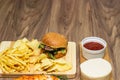 Tasty fast food on table. Pepperoni pizza and pizza Capricciosa , hamburger and potato chips Royalty Free Stock Photo