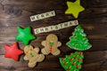 Tasty festive Christmas gingerbread cookies and Merry Christmas inscription on wooden table. Top view