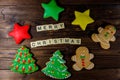 Tasty festive Christmas gingerbread cookies and Merry Christmas inscription on wooden table. Top view