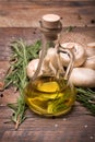 Tasty, fragrant sunflower oil for salads on a wooden background. A few branches of rosemary and mushrooms on a desk.