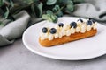 Tasty French eclairs with cream and fresh berries