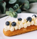 Tasty French eclairs with cream and fresh berries