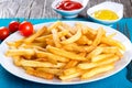 Tasty french fries on plate, on wooden table background Royalty Free Stock Photo