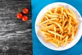 Tasty french fries on plate, on wooden table background Royalty Free Stock Photo