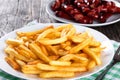 Tasty french fries on plate, on wooden table background Royalty Free Stock Photo