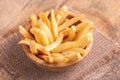 Tasty french fries in wooden bowl on burlap napkin