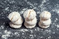 Tasty fresh and airy meringue dessert with nuts on a gray background in icing sugar