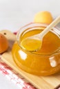 Tasty and Fresh Apricot Jam in a Glass Jar on Wooden Tray Napkin Wooden Spoon Above Vertical Royalty Free Stock Photo