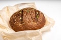 Tasty fresh baked loaf of dark bread with sesame seeds on white background