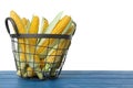 Tasty fresh corn cobs in basket on blue wooden table against white background Royalty Free Stock Photo