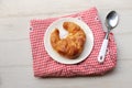 tasty Fresh crispy croissants arranged in white plate on cloth . Flat lay composition food photography.