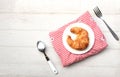 tasty Fresh crispy croissants arranged in white plate on cloth . Flat lay composition food photography.