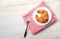 tasty Fresh crispy croissants arranged in white plate on cloth . Flat lay composition food photography.