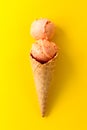 Tasty fresh fruity ice cream in ice cream cone on yellow vibrant