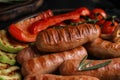 Tasty fresh grilled sausages with vegetables on table Royalty Free Stock Photo