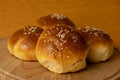 Tasty fresh homemade baked buns with sesame on a wooden plate and a yellow background. Bread. Burger buns Royalty Free Stock Photo