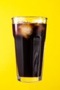 Tasty fresh iced cold black coffee with ice on yellow vivid back
