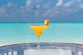 Tasty fresh icy yellow color cocktail on the glass table at the beach with ocean Royalty Free Stock Photo