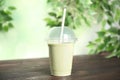 Tasty fresh milk shake in plastic cup on wooden table Royalty Free Stock Photo