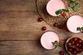 Tasty fresh milk shakes with cherries on wooden table, flat lay. Space for text Royalty Free Stock Photo